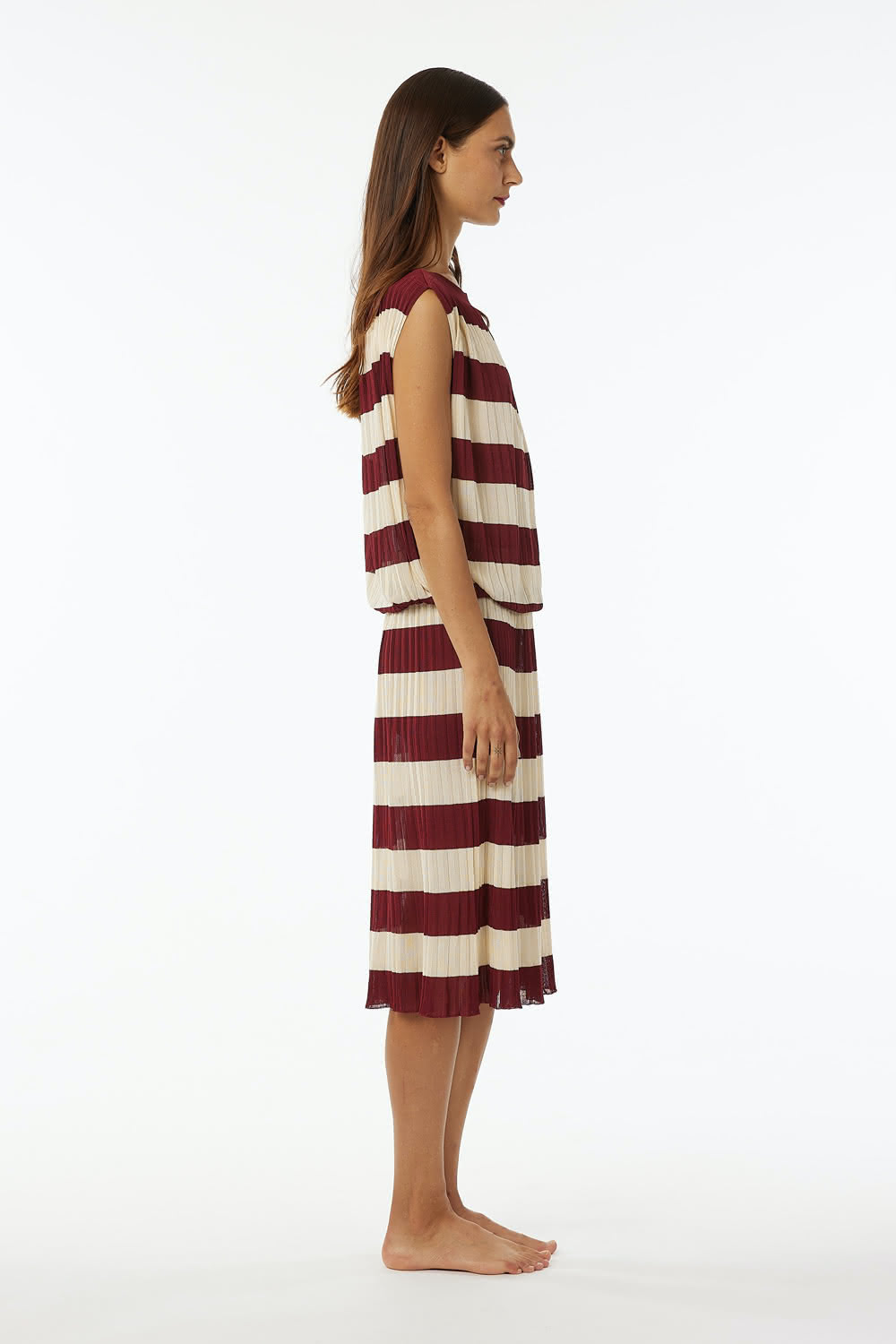 Pleated shiny viscose dress with elastic band at waist, dropped sleeve boat neck. Length at knee.