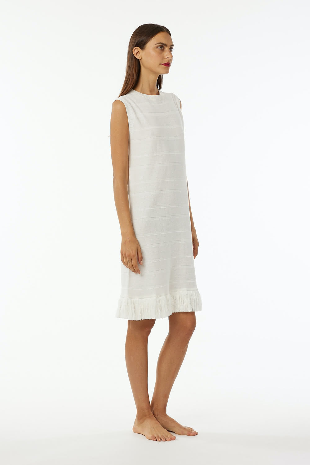 Crew neck sleeveless dress with flat rib, length at knee and cotton fringes at bottom.