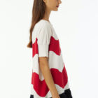 Oversized boat neck sweater with waves intarsia, sleeve at elbow, contrasted color fringes. Wide vestibility.