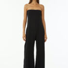 Shoulderless jumpsuit in stretch viscose jersey tight at chest and wider underneath large leg with pockets.