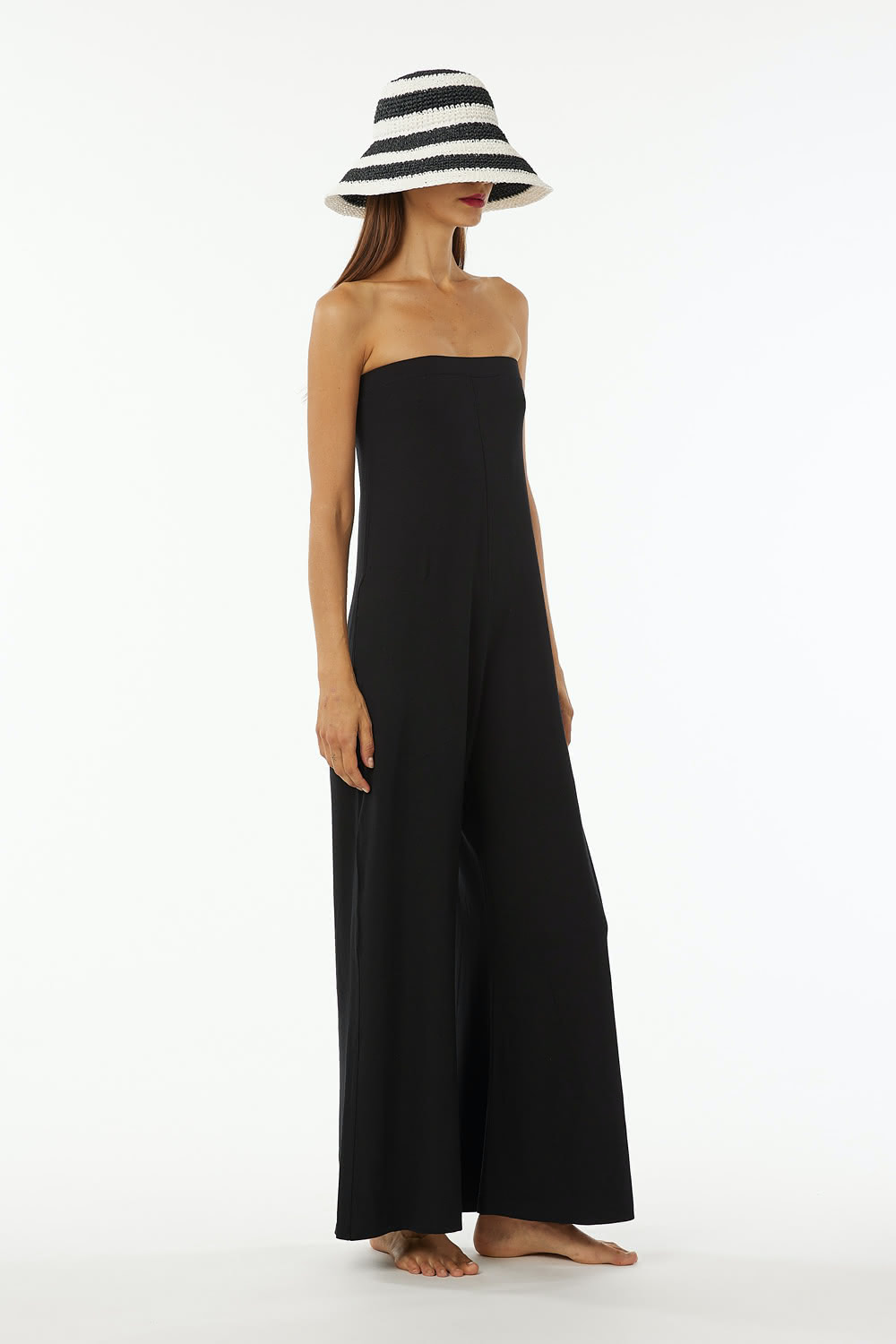 Shoulderless jumpsuit in stretch viscose jersey tight at chest and wider underneath large leg with pockets.