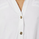 Viscose stretch jersey shirt with long sleeves rounded bottom and small golden buttons.